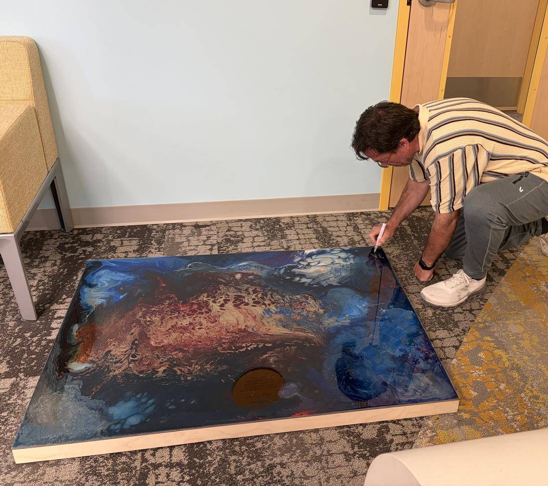 The artist signing a donated work on site